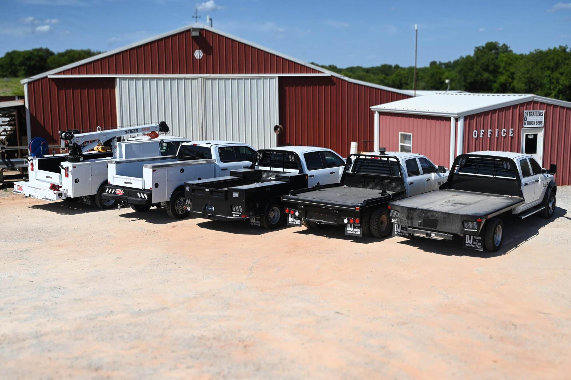 Flatbeds, service bodies, and crane truck lined up outside DJ FleetWorX in Wayne, Oklahoma.